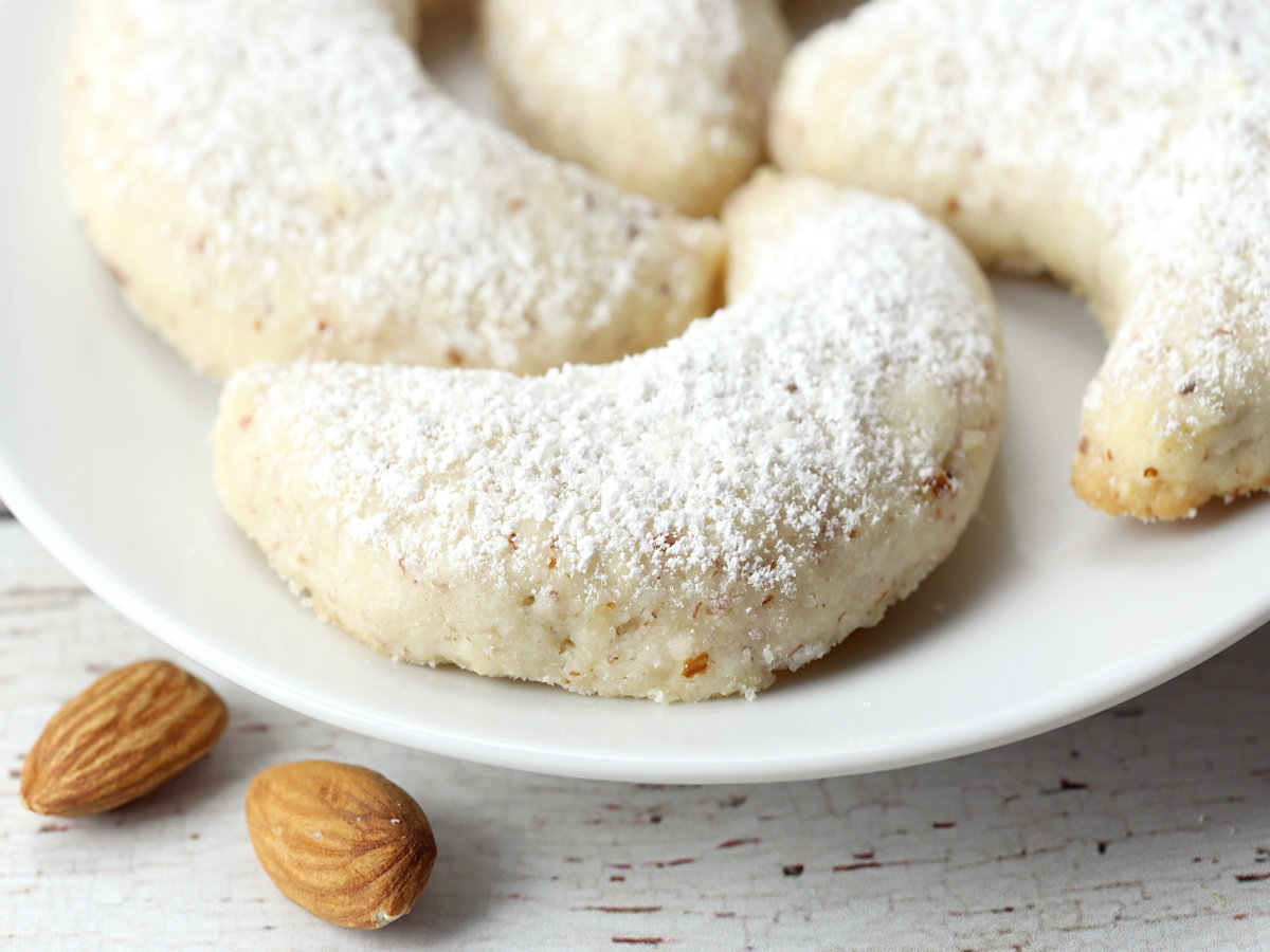 Powdered sugar dusted on top of a vanilla crescent cookie.