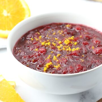 A bowl of cranberry sauce topped with orange zest.