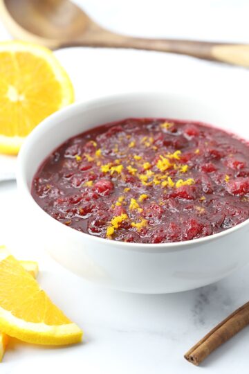 A bowl of cranberry sauce topped with orange zest.