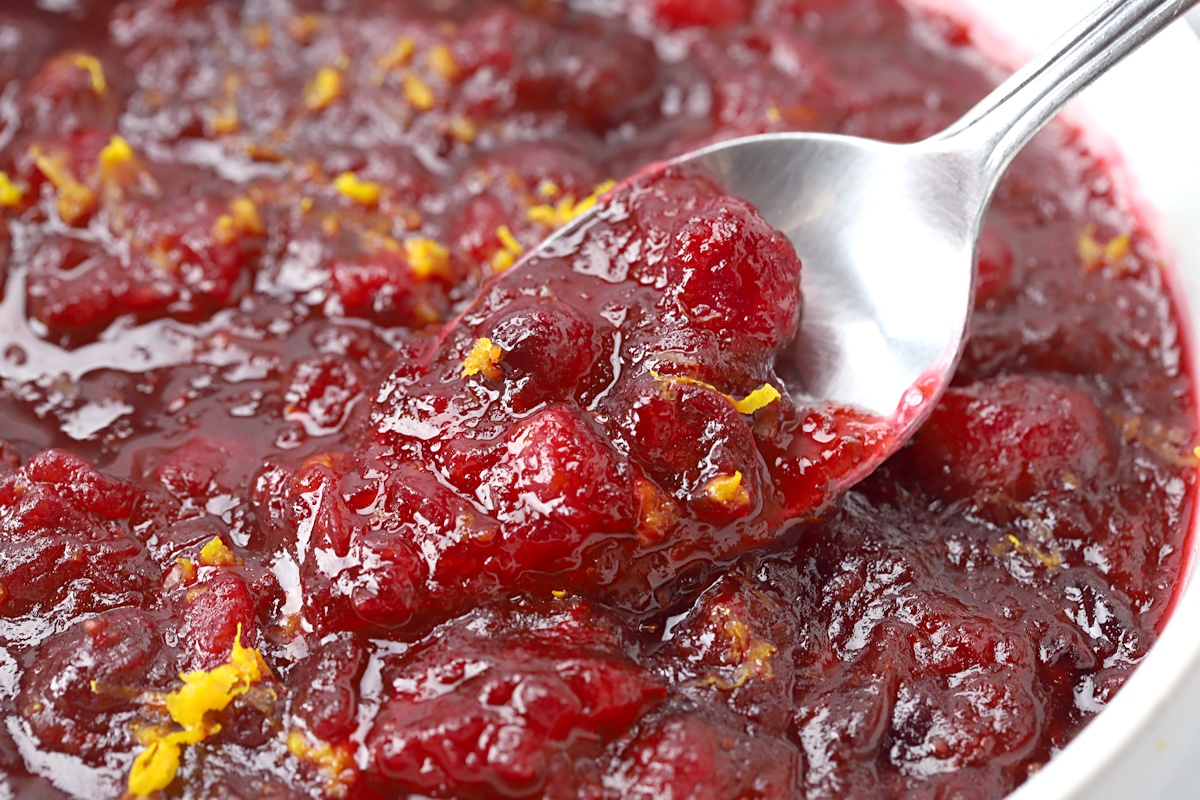 A spoon scooping cranberry sauce.