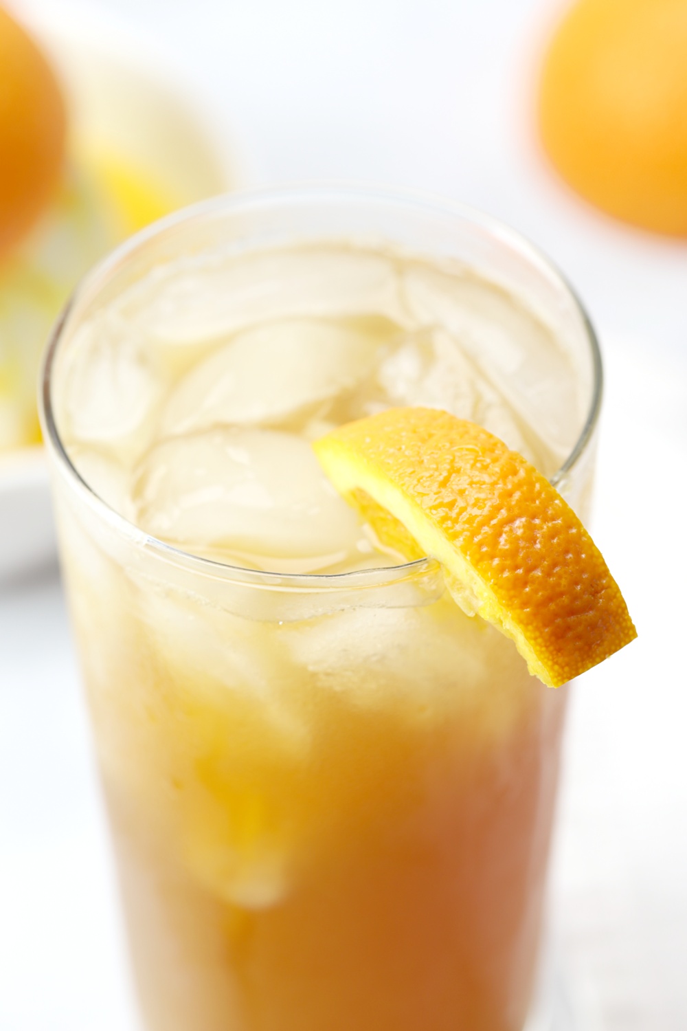 A glass of fireball orange sweet tea with an orange slice on the rim.