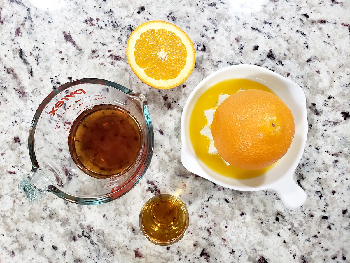 Ingredients for making a drink with orange juice, fireball whisky, and iced tea.