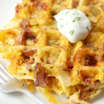 Dollop of sour cream and chives on top of savory waffles.