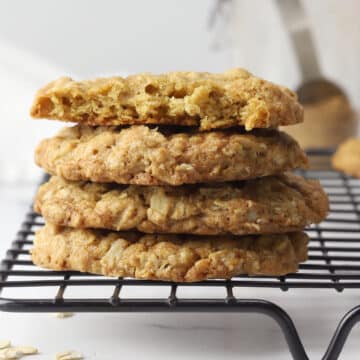 Chai spiced oatmeal cookies stacked on a cooling rack.