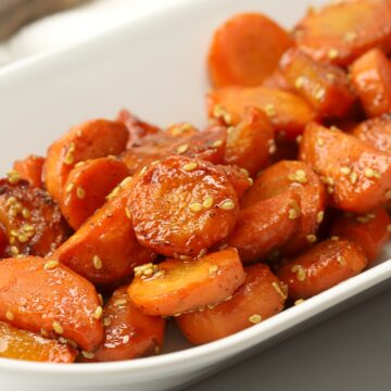 Honey glazed carrots on a white serving plate.