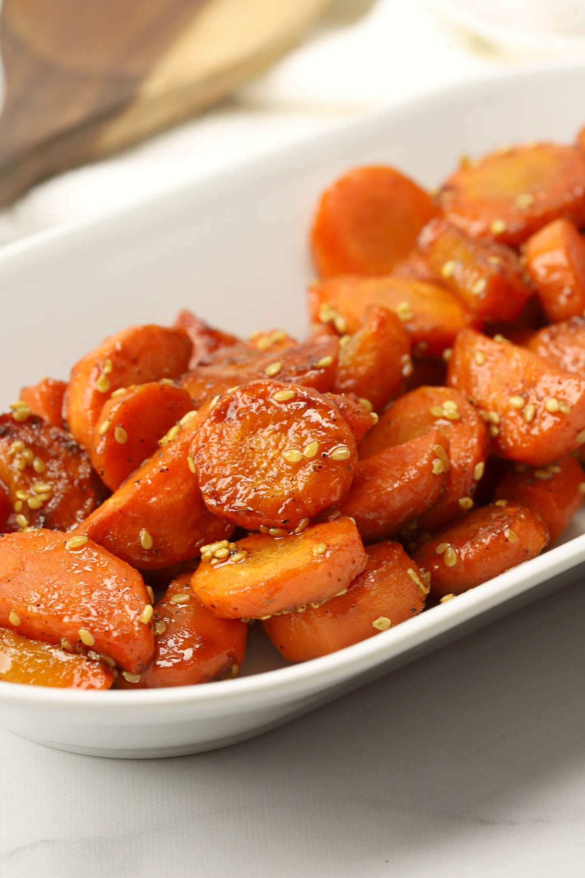 Honey glazed carrots on a white serving plate.