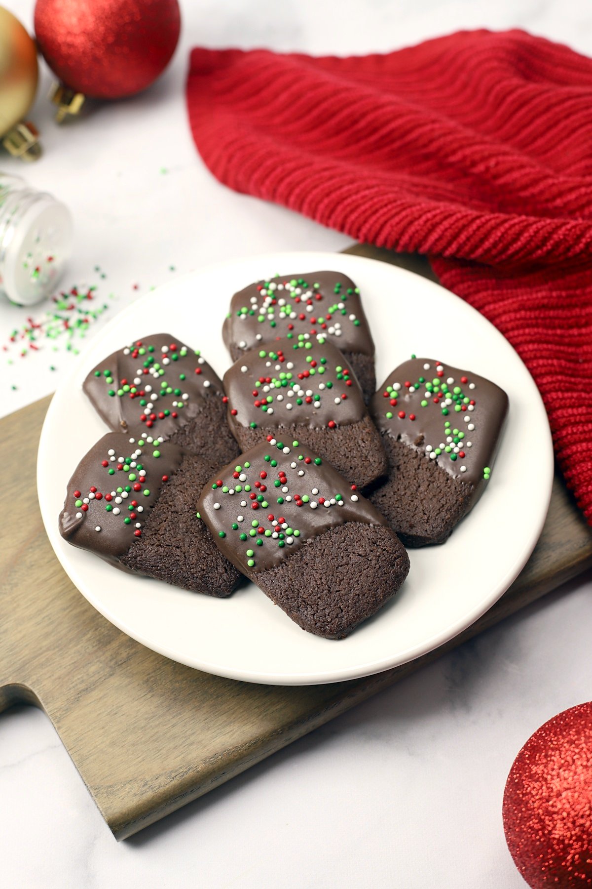 A plate of Christmas cookies on a cutting board.