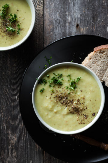 creamy soup in a white bowl, served with crusty bread.