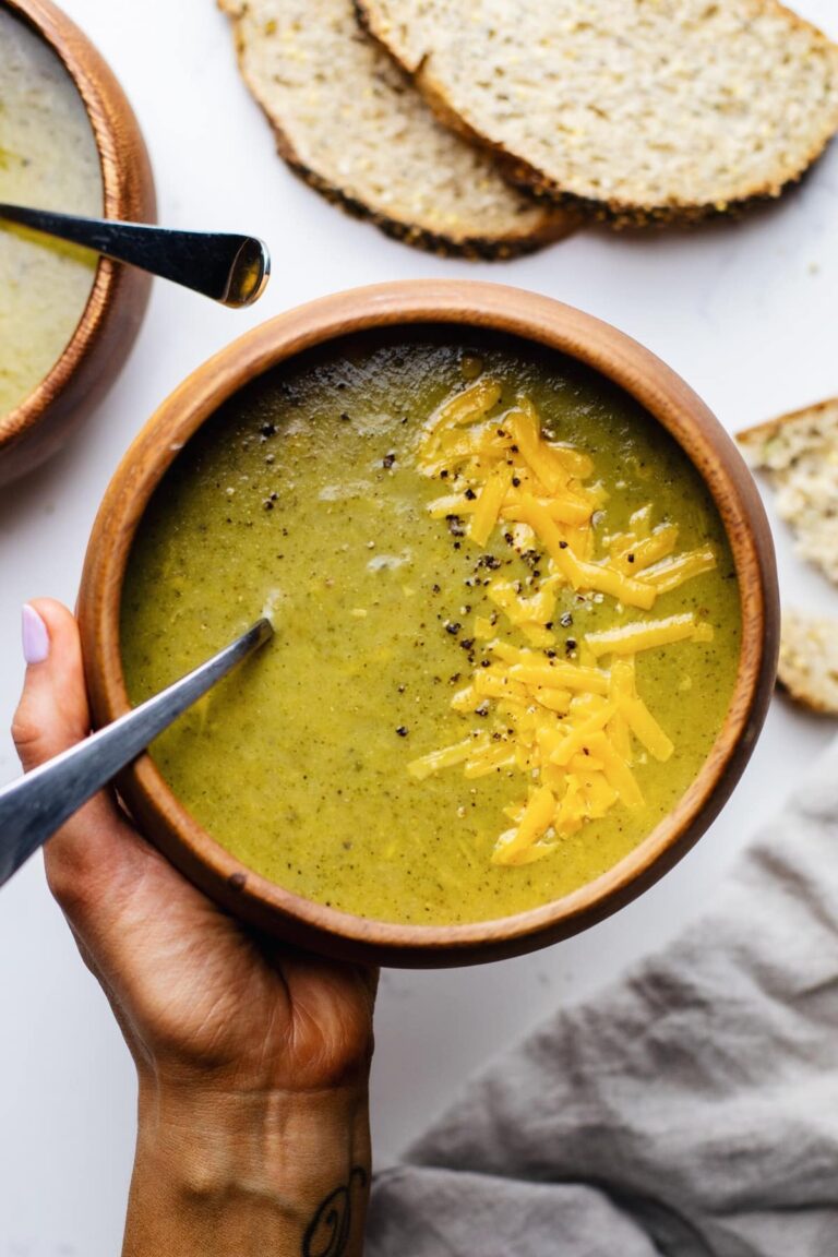 Broccoli soup in a bowl, topped with shredded cheese.