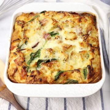 A white casserole dish filled with breakfast strata.