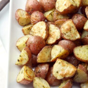 Quartered red potatoes coated in ranch seasoning on a serving plate.