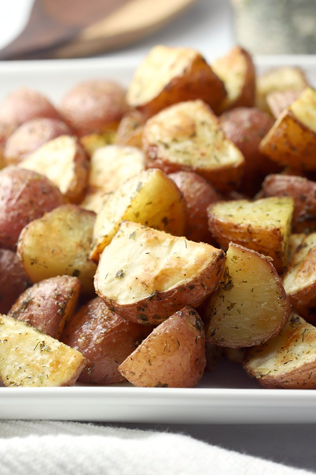 A white plate filled with red potatoes.