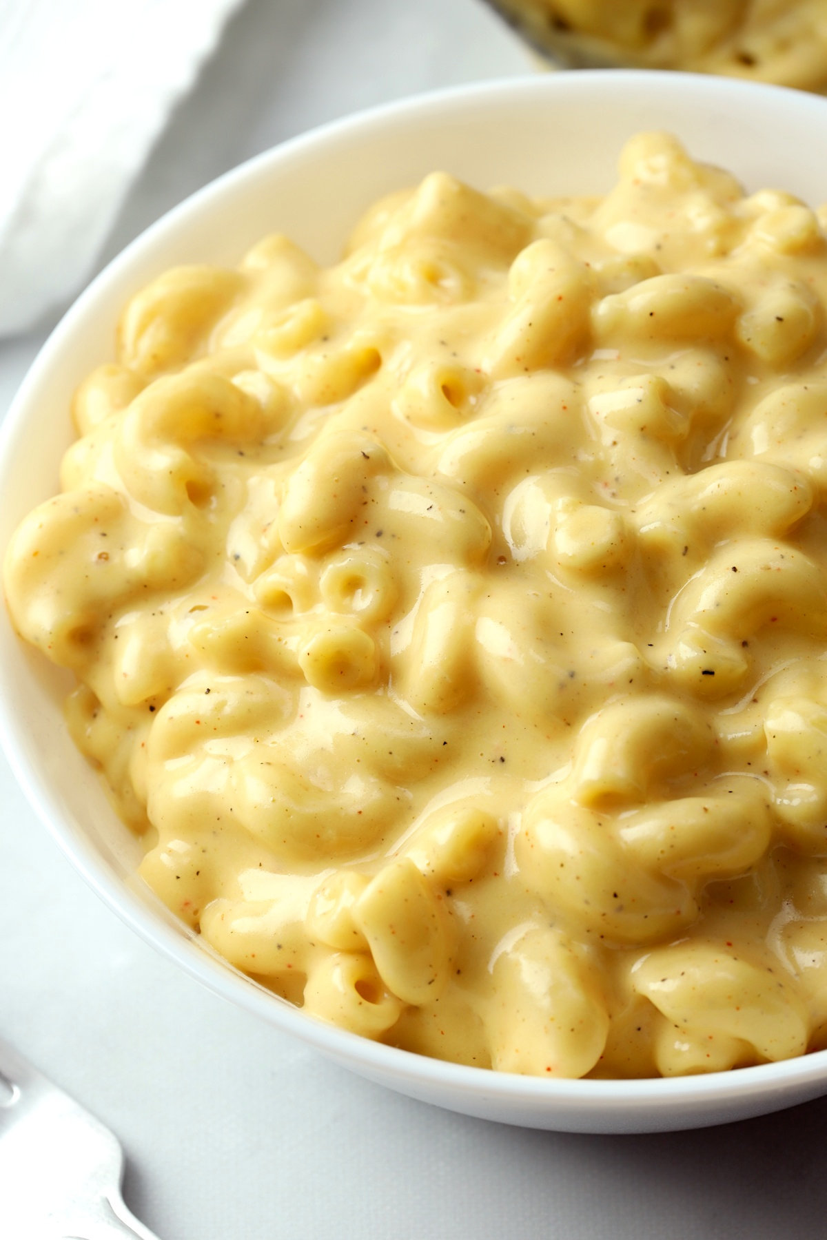 Creamy stovetop mac and cheese in a white bowl.