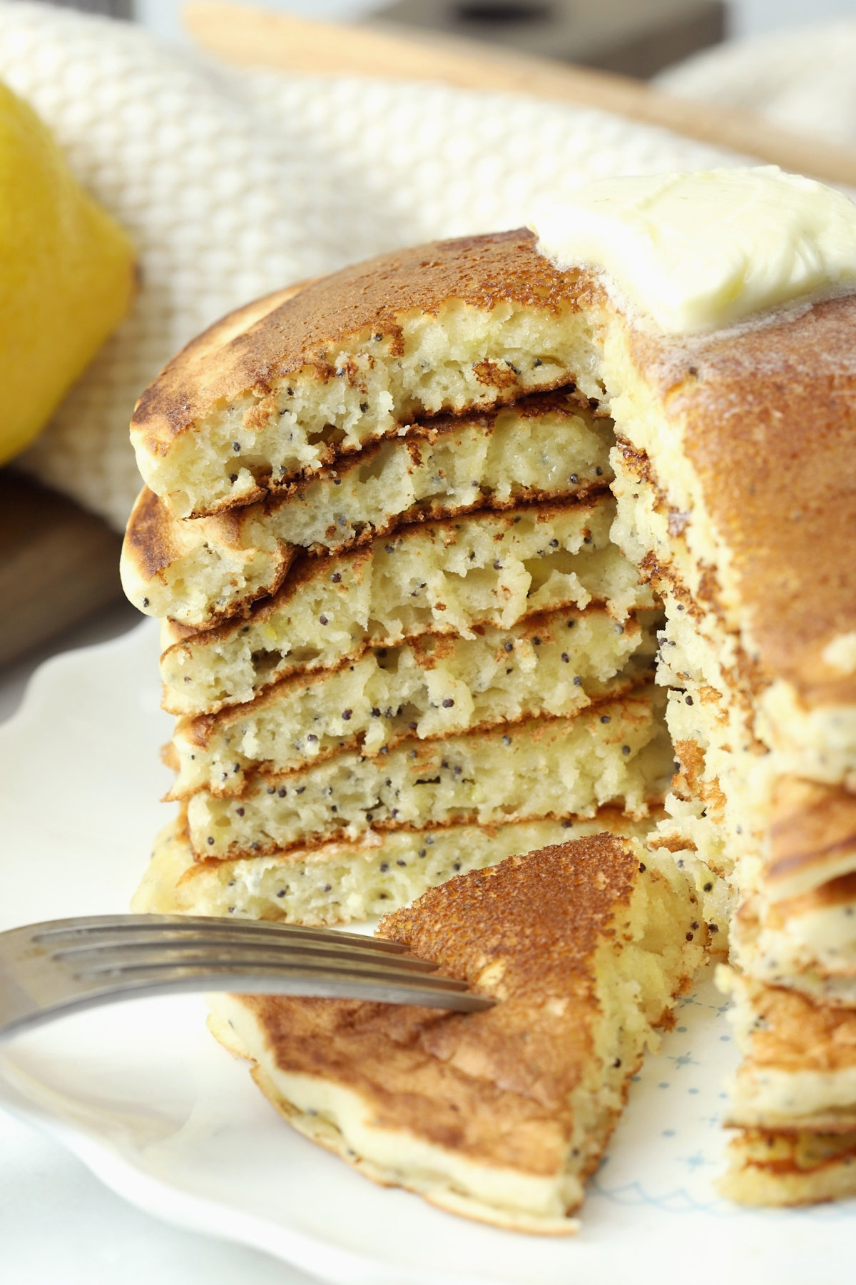 A stack of pancakes sliced into to show layers and poppy seeds inside.