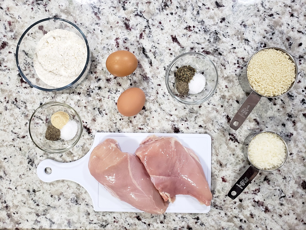 Chicken breasts and other ingredients on a counter top.