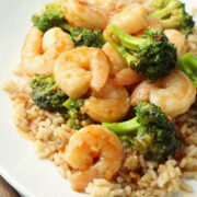 A white plate with shrimp, broccoli, and rice.