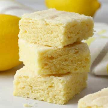 Lemon sugar cookie bars stacked on a counter top.