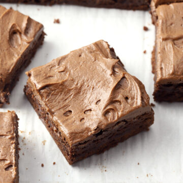 A sliced brownie with chocolate frosting.