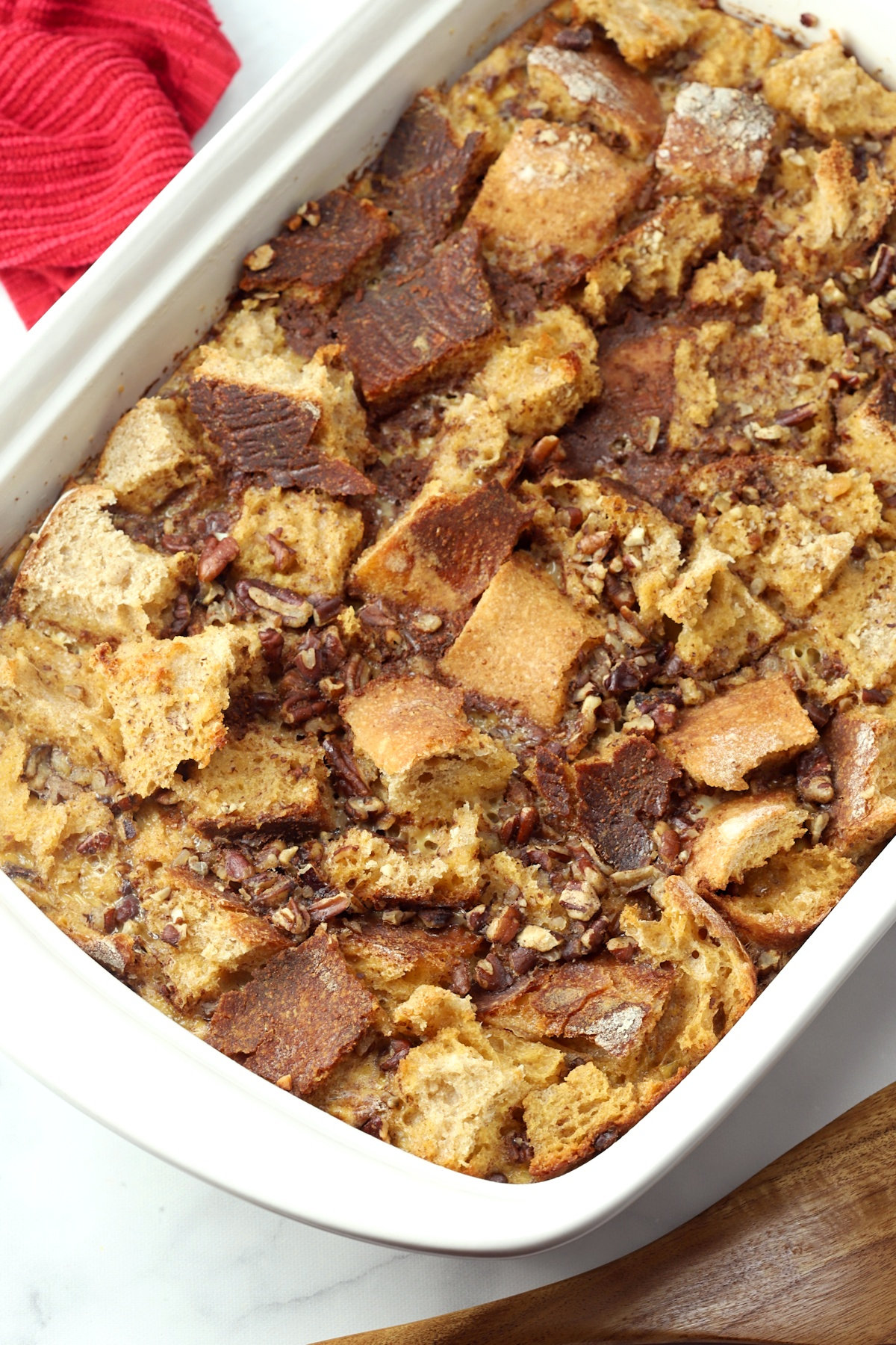 A 9x13 pan filled with bread cubes and pecans.