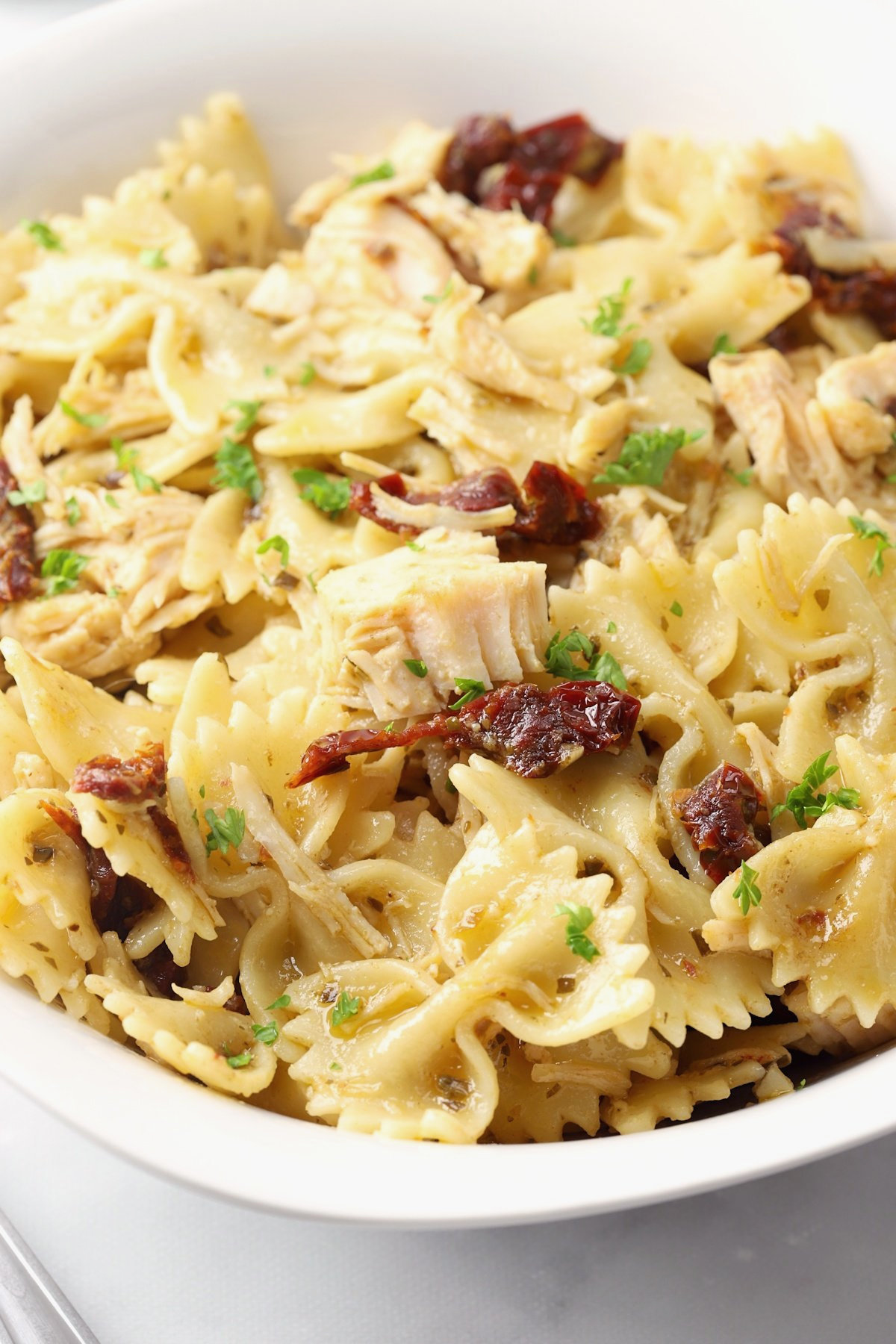 Bow tie pasta coated in a basil pesto sauce.