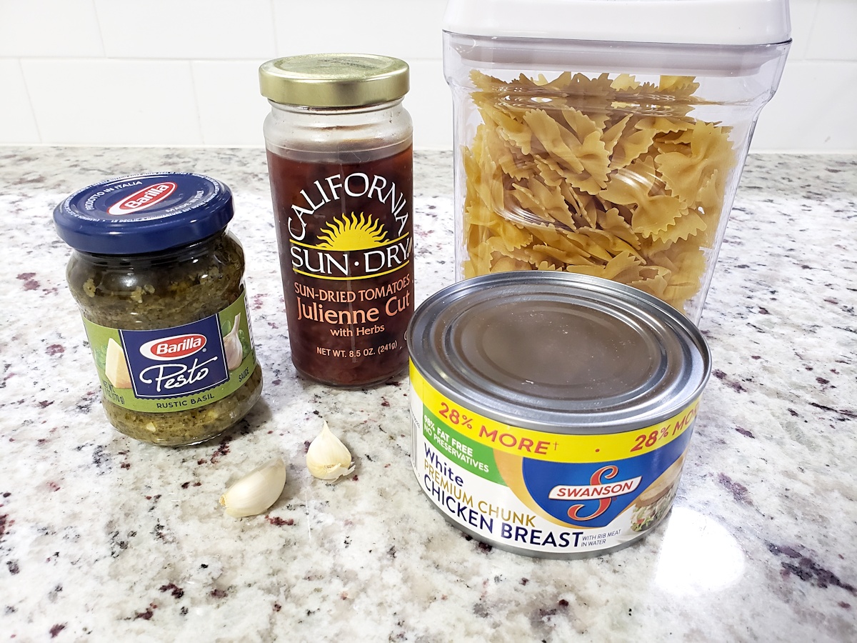 The five ingredients needed to make pesto chicken pasta.