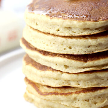 A stack of applesauce pancakes on a white serving plate.