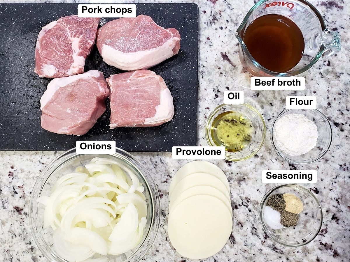 Pork chops and other ingredients on a counter top.