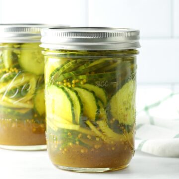 A mason jar filled with pickles and onions.