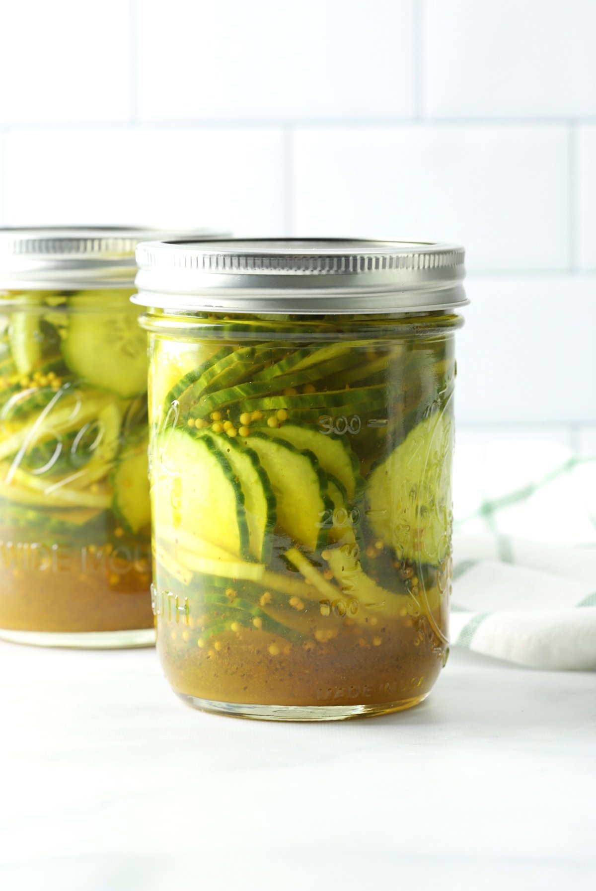 A mason jar filled with pickles and onions.