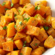 Butternut squash cubed and topped with fresh parsley.