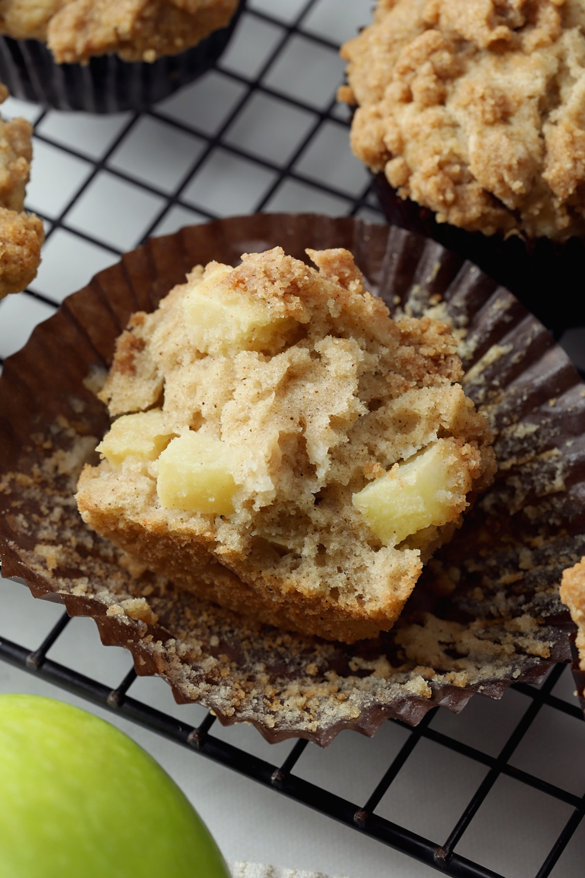 A muffin torn in half to show apple pieces.