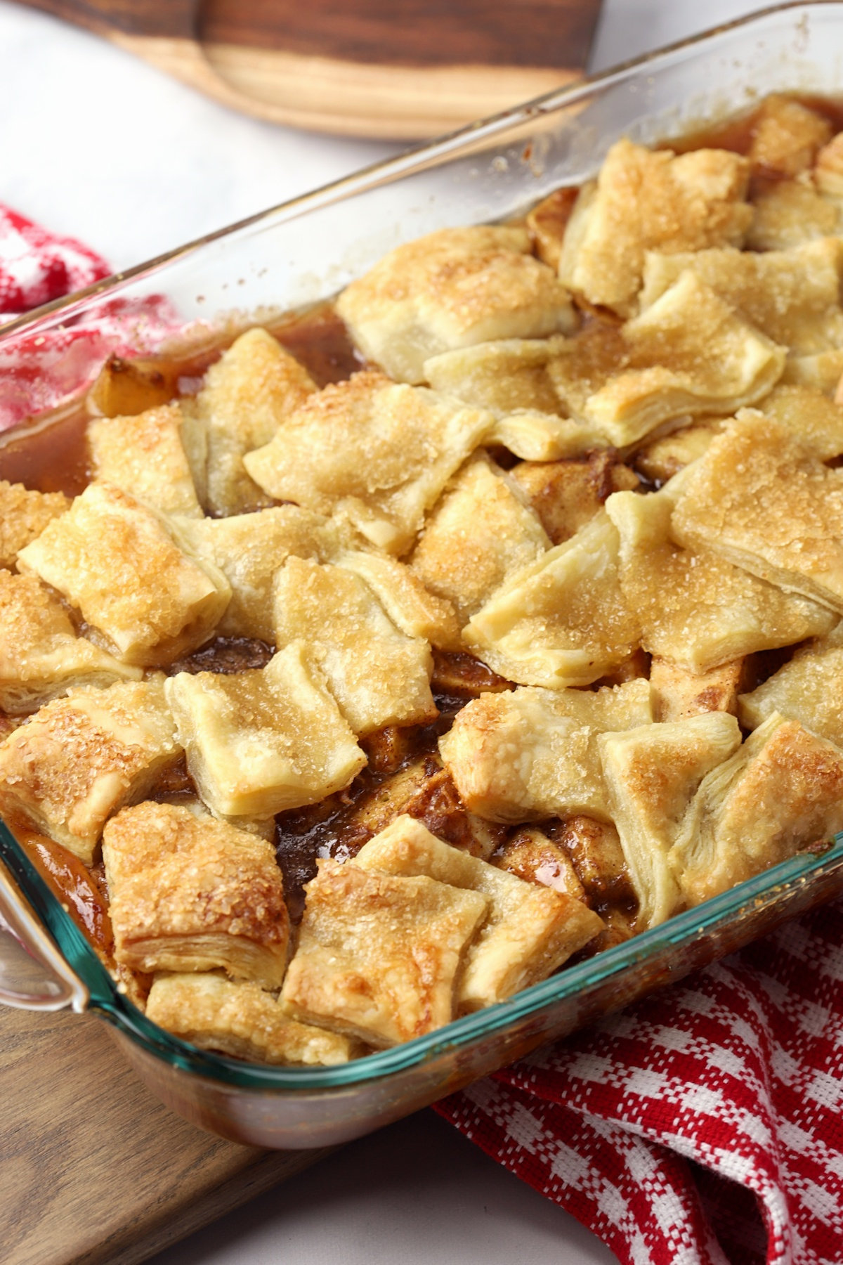 Puff pastry on top of apple pie filling in a glass dish.