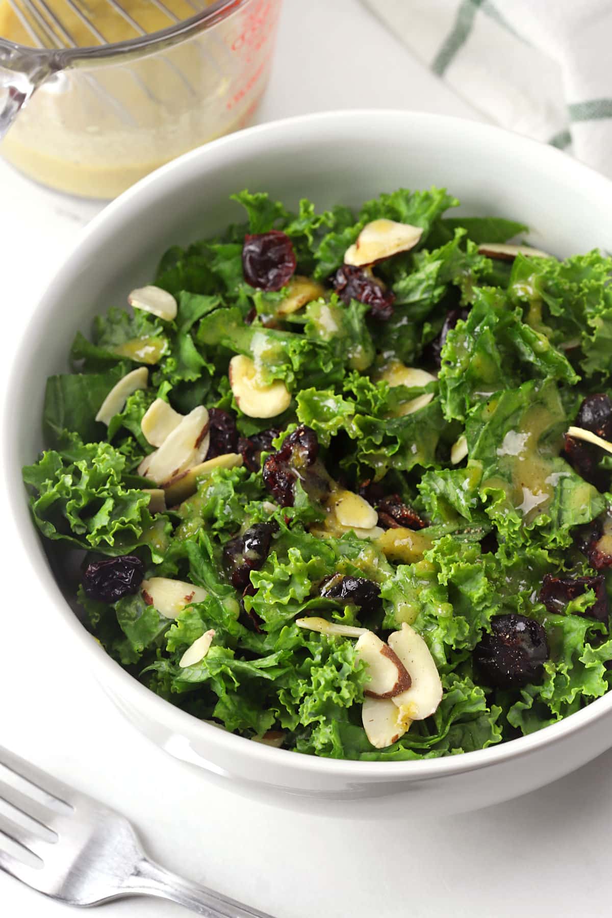 Prepared kale cranberry salad in a white serving bowl.