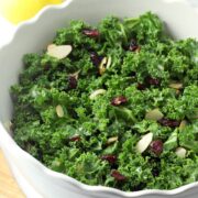 Salad bowl filled with kale, cranberries, and almonds.