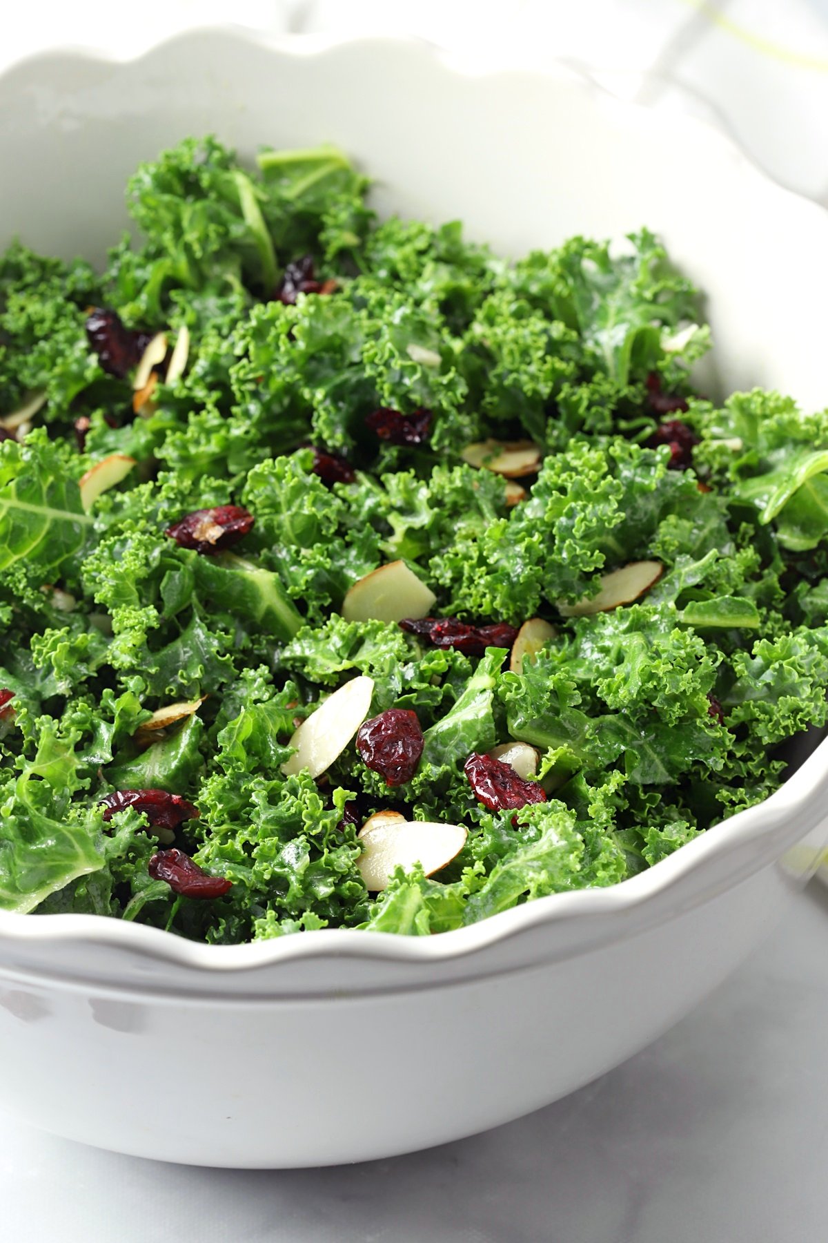 Kale salad in a white, scalloped edge bowl.