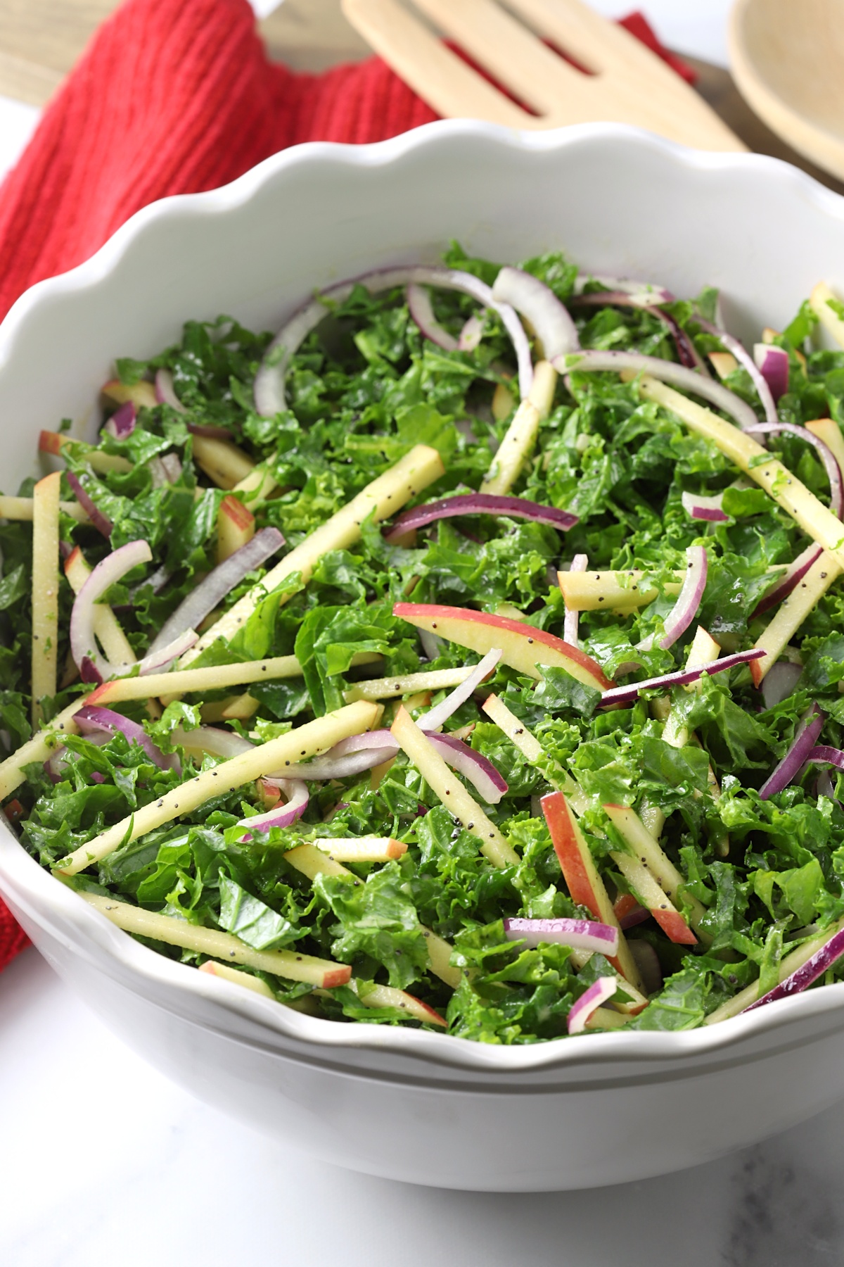 A white scalloped edge bowl filled with salad.