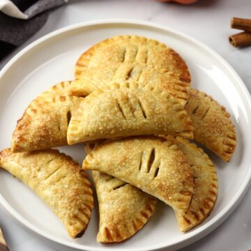 A white plate filled with pumpkin pasties.