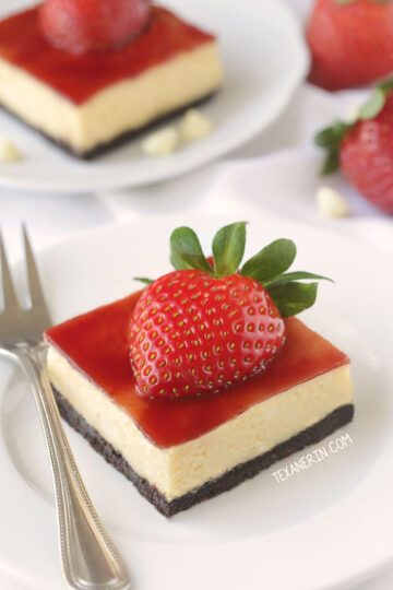 A strawberry cheesecake bar on a plate with a fork.