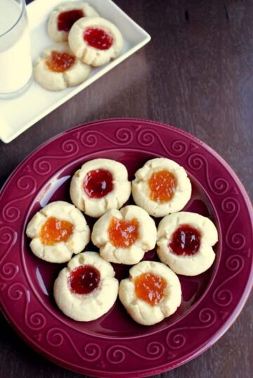 thumbprint cookies on a red plate.