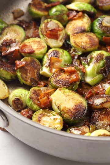 Brussels sprouts and bacon in a metal pan.