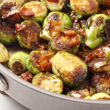 Brussels sprouts and bacon in a metal pan.