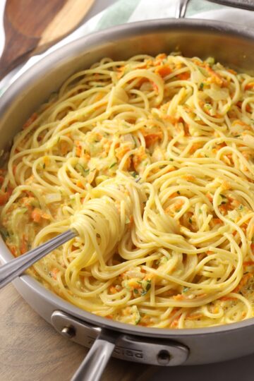 Saute pan with a fork swirling spaghetti.