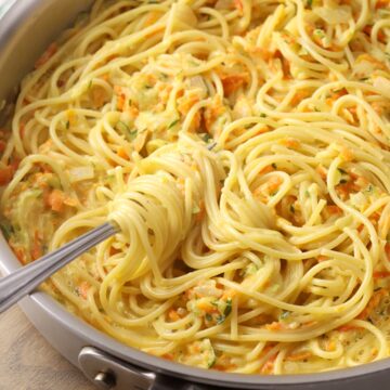 Saute pan with a fork swirling spaghetti.