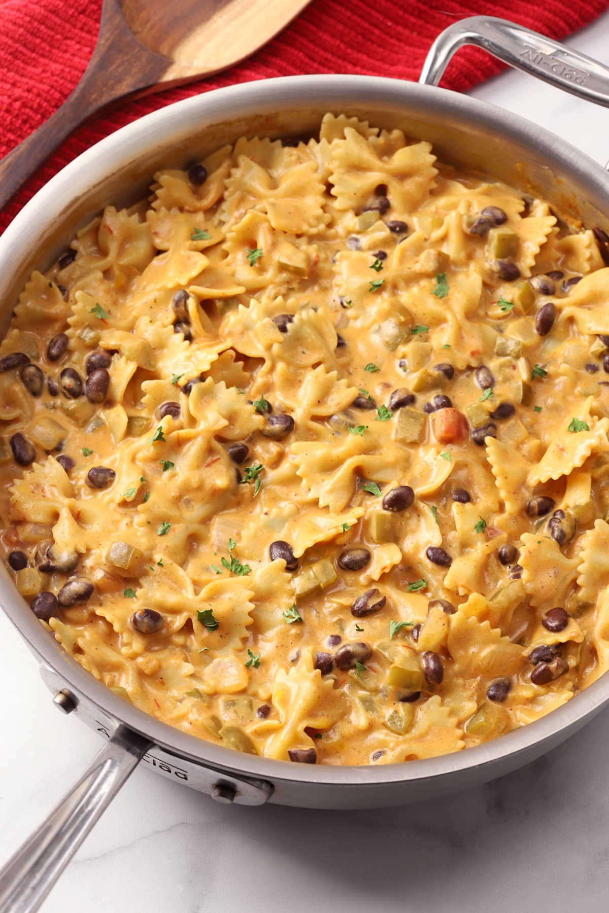 A saute pan filled with bow tie pasta and black beans.