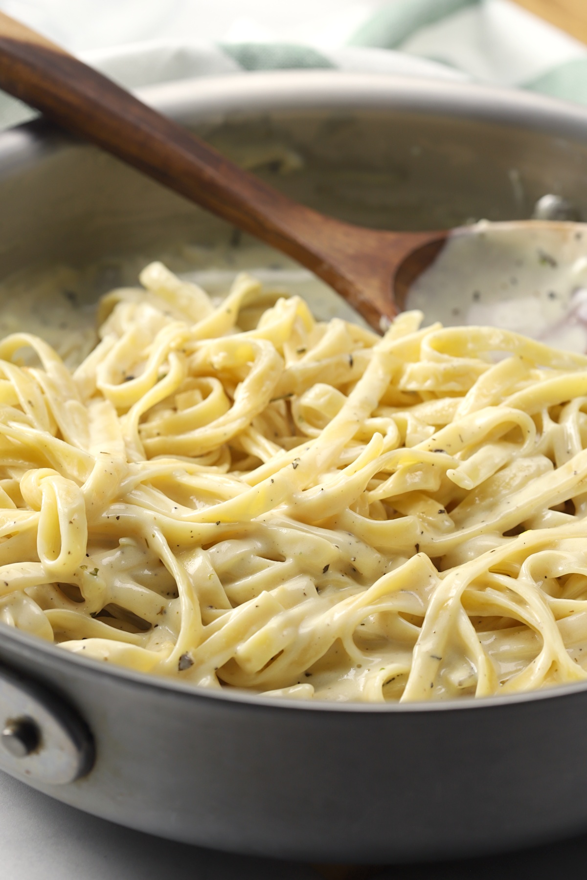 Fettuccine coated in alfredo sauce in a pan.