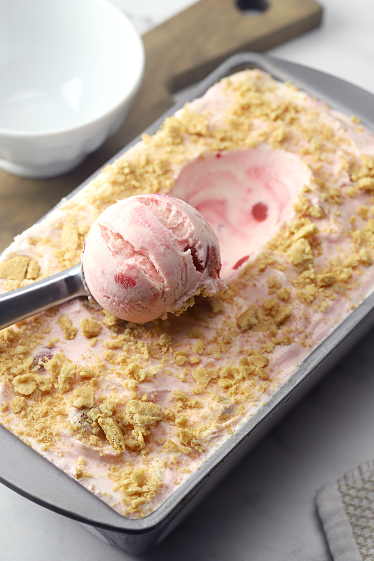 Scooping ice cream from a loaf pan.