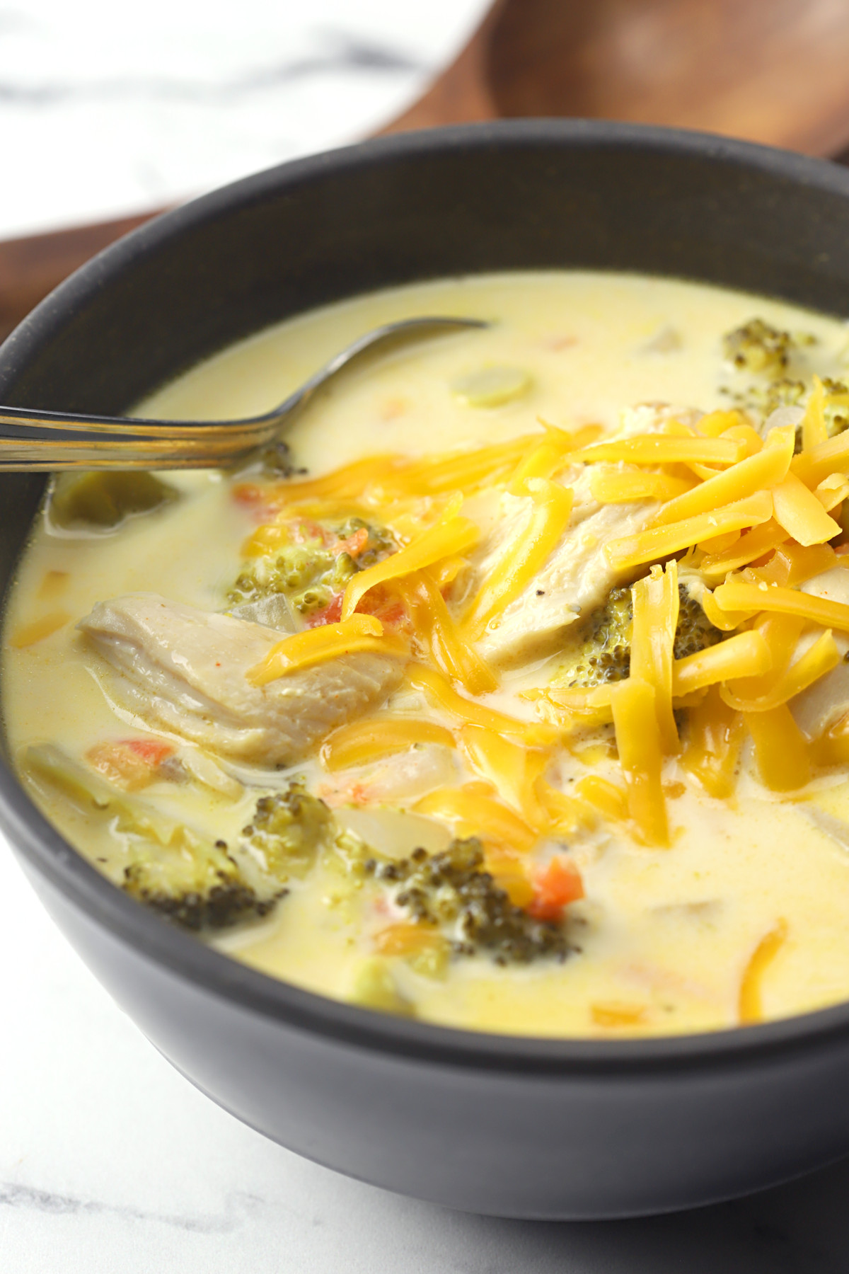Shredded cheese melting on top of a creamy soup.