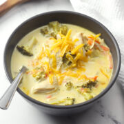 Bowl of chicken broccoli cheese soup with a spoon.