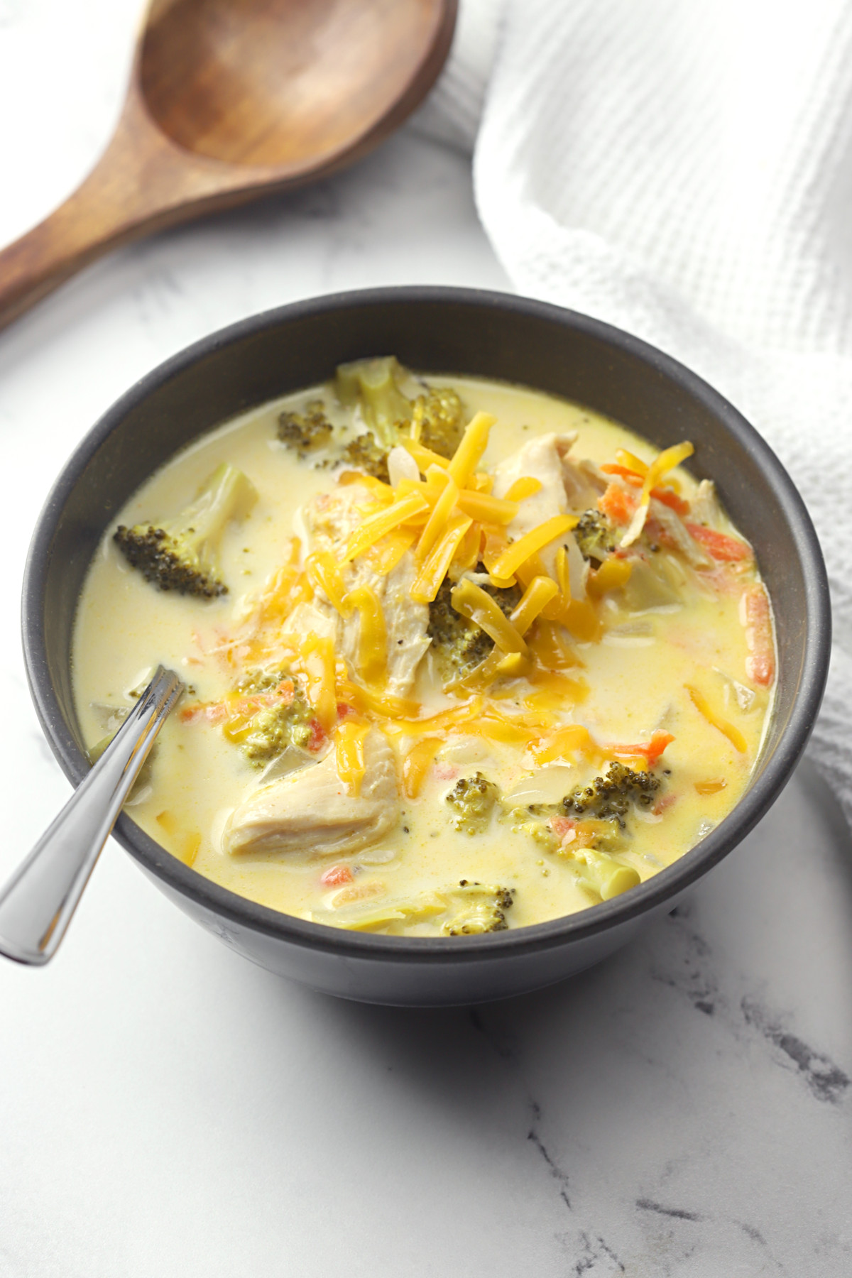 Bowl of chicken broccoli cheese soup with a spoon.