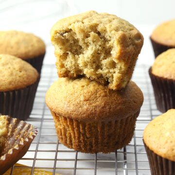 Banana nut muffins stacked on a cooling rack.